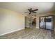 Open living room boasts wood floors, ceiling fan, and sliding glass door to bring in natural light at 8230 E Navarro Ave, Mesa, AZ 85209