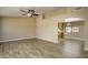 Spacious living room with wood-style tile flooring, neutral paint, abundant natural light, and an open floor plan at 8230 E Navarro Ave, Mesa, AZ 85209