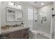 Bathroom features a vanity with a quartz countertop, decorative mirror, and glass enclosed shower at 9441 N 129Th Pl, Scottsdale, AZ 85259