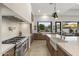 Modern kitchen with stainless steel range, farmhouse sink, and scenic backyard views at 9441 N 129Th Pl, Scottsdale, AZ 85259