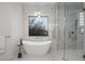 Luxurious bathroom featuring a soaking tub, glass shower, marble walls, and modern fixtures at 9441 N 129Th Pl, Scottsdale, AZ 85259