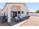 Backyard featuring gravel, patio chairs, and a grill outside of the sliding glass door at 9791 N 118Th Way, Scottsdale, AZ 85259