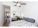 Bedroom with bed, ceiling fan, wood-look floors and sliding mirror doors reflecting the room at 9791 N 118Th Way, Scottsdale, AZ 85259