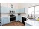 Bright kitchen with blue cabinets, stainless steel appliances, and white countertops at 9791 N 118Th Way, Scottsdale, AZ 85259