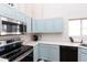 Well-lit kitchen featuring light blue cabinetry, stainless-steel appliances and ample counter space at 9791 N 118Th Way, Scottsdale, AZ 85259