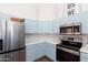 Charming kitchen with light blue cabinetry, subway tile backsplash, and stainless-steel appliances at 9791 N 118Th Way, Scottsdale, AZ 85259