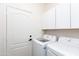 Well-lit laundry room with white cabinets and modern washing machines at 9791 N 118Th Way, Scottsdale, AZ 85259