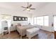 Bright main bedroom with ceiling fan, dual nightstands and bench at 9791 N 118Th Way, Scottsdale, AZ 85259