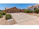 Charming home exterior featuring a wide driveway, three-car garage, and desert landscaping with lush flowering bushes at 10931 N 129Th Way, Scottsdale, AZ 85259