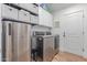 Well-equipped laundry room featuring stainless steel washer and dryer and ample storage cabinets at 10931 N 129Th Way, Scottsdale, AZ 85259