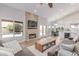 Bright living room with a stone fireplace, hardwood floors, backyard view and open layout with view to the kitchen at 10931 N 129Th Way, Scottsdale, AZ 85259