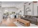 Open-concept living space with a stone fireplace, hardwood floors, eat-in kitchen, and archway to the dining area at 10931 N 129Th Way, Scottsdale, AZ 85259