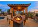 Inviting outdoor space with a fire pit and pergola strung with festive lights at 10931 N 129Th Way, Scottsdale, AZ 85259