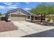 View of the well-maintained home with desert landscaping and a spacious driveway at 11330 W Eden Mckenzie Dr, Surprise, AZ 85378