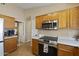 Well-lit kitchen features stainless steel appliances, light countertops and matching cabinetry at 11330 W Eden Mckenzie Dr, Surprise, AZ 85378