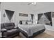 Spacious main bedroom with gray decor, a comfy chair, and ample natural light from the windows at 11330 W Eden Mckenzie Dr, Surprise, AZ 85378