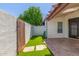 Spacious backyard with artificial grass, privacy wall, and a convenient access gate at 1174 E Belmont Ave, Phoenix, AZ 85020