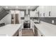 Stylish kitchen featuring stainless steel appliances, white cabinetry, quartz countertops, and gray accent walls at 1174 E Belmont Ave, Phoenix, AZ 85020
