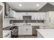 Sleek kitchen featuring white cabinetry, quartz countertops, stainless steel appliances, and modern fixtures at 1174 E Belmont Ave, Phoenix, AZ 85020