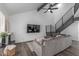 Bright living room featuring a cozy gray sectional sofa, fireplace, large television, and stylish staircase at 1174 E Belmont Ave, Phoenix, AZ 85020