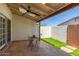 Cozy covered patio with a ceiling fan, a small seating area, and an artificial grass accent at 1174 E Belmont Ave, Phoenix, AZ 85020