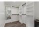 Bright walk-in closet with adjustable shelving, wood floor and mirror to the en suite bathroom at 1174 E Belmont Ave, Phoenix, AZ 85020