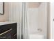 Bright bathroom featuring a white shower-tub combo, stylish vanity with a dark wood finish, and modern fixtures at 12811 N 19Th Pl, Phoenix, AZ 85022