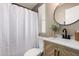 Updated bathroom with modern vanity, updated fixtures, round mirror and shower-tub combo at 12811 N 19Th Pl, Phoenix, AZ 85022