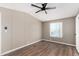 Bright bedroom with wood-look flooring, ceiling fan, and natural light from the window at 12811 N 19Th Pl, Phoenix, AZ 85022