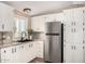 Bright kitchen featuring white cabinets, black fixtures, and stainless steel refrigerator at 12811 N 19Th Pl, Phoenix, AZ 85022