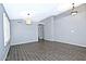 Spacious living room featuring gray walls, wood-look tile flooring, modern lighting, and plantation shutters at 1741 S Clearview Ave # 13, Mesa, AZ 85209