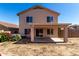 The back of a tan two-story home with covered patio and private backyard at 22322 W Loma Linda Cir, Buckeye, AZ 85326