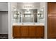 Bright bathroom featuring a double sink vanity with wooden cabinets and a large mirror at 22322 W Loma Linda Cir, Buckeye, AZ 85326