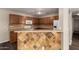 Kitchen featuring wood cabinets, white appliances, and tiled breakfast bar at 22322 W Loma Linda Cir, Buckeye, AZ 85326