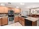 Open kitchen boasts stainless steel appliances, wood cabinets and stone backsplash at 22543 W Cocopah St, Buckeye, AZ 85326