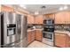 Bright kitchen featuring stainless steel appliances, wood cabinets, and tile flooring at 22543 W Cocopah St, Buckeye, AZ 85326
