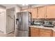 Updated kitchen features stainless steel refrigerator and wood cabinets at 22543 W Cocopah St, Buckeye, AZ 85326