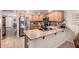 Well-lit kitchen features stainless steel appliances, natural wood cabinets and stone backsplash at 22543 W Cocopah St, Buckeye, AZ 85326