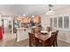 Eat-in kitchen features wood cabinetry, stainless steel appliances, tile floor, and a four-chair dining table at 22543 W Cocopah St, Buckeye, AZ 85326
