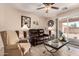 Cozy living room showcases a leather sofa, comfortable arm chair, and sliding glass door to the patio at 22543 W Cocopah St, Buckeye, AZ 85326