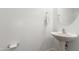 Well-lit powder room features a pedestal sink and a modern, minimalist design at 23042 E Excelsior Ave, Queen Creek, AZ 85142
