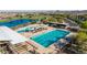 Aerial view of a community pool and lounge area with a lake and recreational spaces at 23042 E Excelsior Ave, Queen Creek, AZ 85142