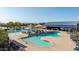 Inviting community pool with tables, umbrellas, lounge chairs and covered areas at 23042 E Excelsior Ave, Queen Creek, AZ 85142