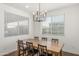 Bright dining room with a large wooden table, modern lighting, and ample natural light at 23042 E Excelsior Ave, Queen Creek, AZ 85142