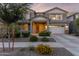 Charming two-story home featuring a landscaped yard and a welcoming front porch with beautiful flowerbeds at 23042 E Excelsior Ave, Queen Creek, AZ 85142