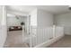 Upstairs hallway with white railing overlooking the open-concept living space, offers seamless flow at 23042 E Excelsior Ave, Queen Creek, AZ 85142