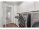 Modern laundry room featuring white cabinets and newer stainless steel washer and dryer units at 23042 E Excelsior Ave, Queen Creek, AZ 85142