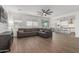 Open-concept living room with hardwood floors, ceiling fan, and a view of the modern kitchen at 23042 E Excelsior Ave, Queen Creek, AZ 85142