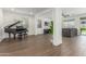 Spacious living room with hardwood floors, a grand piano, and comfortable seating with natural light at 23042 E Excelsior Ave, Queen Creek, AZ 85142