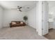 Spacious living room features a fan, plush carpeting, and seamless access to the bathroom at 23042 E Excelsior Ave, Queen Creek, AZ 85142